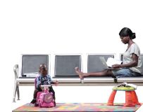 A mother studying on the laptop with the child playing in the background