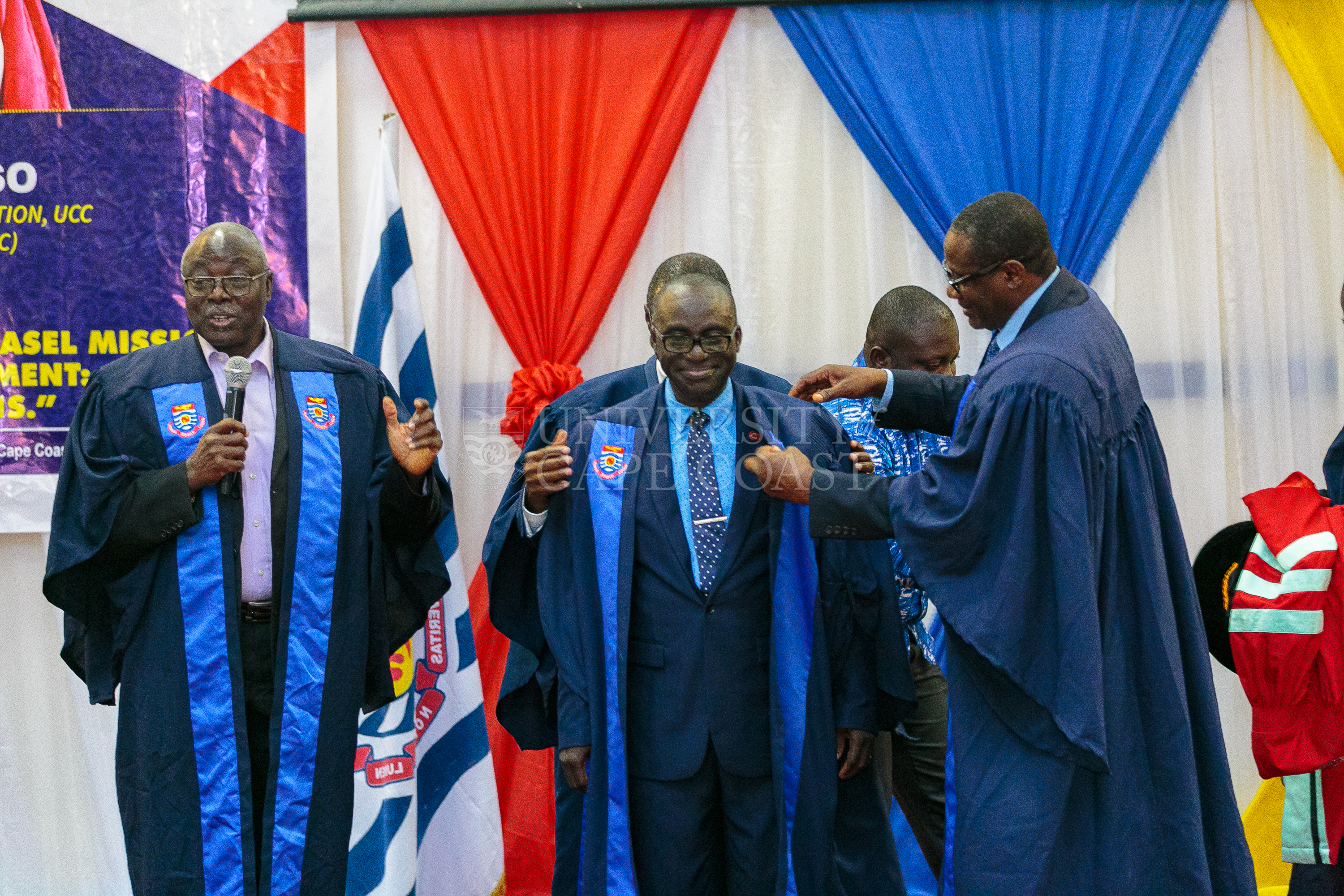 Rev. Prof. Asare-Danso being robed by Prof. Philip Ebow Bondzie into the College of Professors. With the microphone is former VC, Prof. D. D. Kuupole